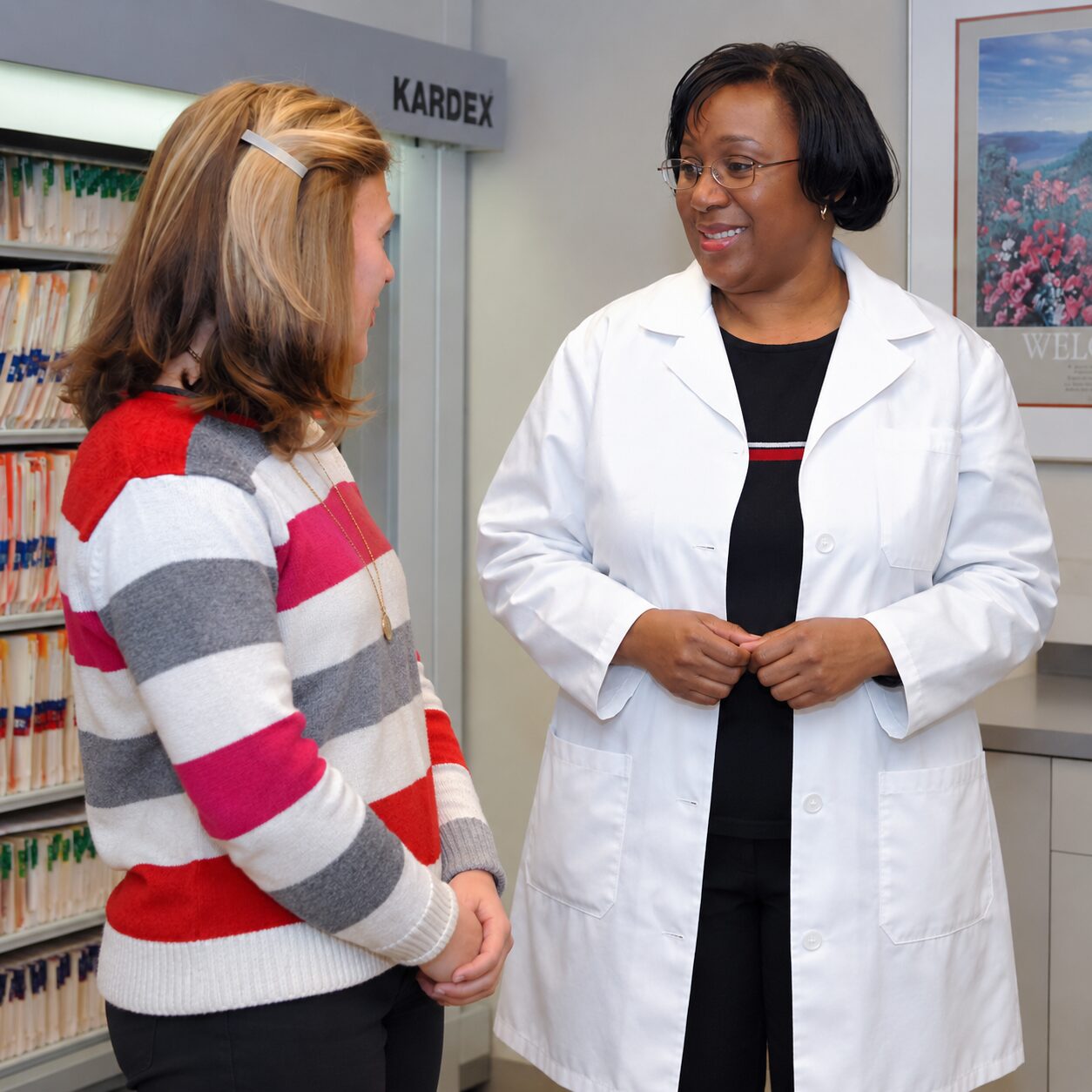 Two people speaking in a clinical or research setting, representing a biotechnology internship environment in Cape Town.