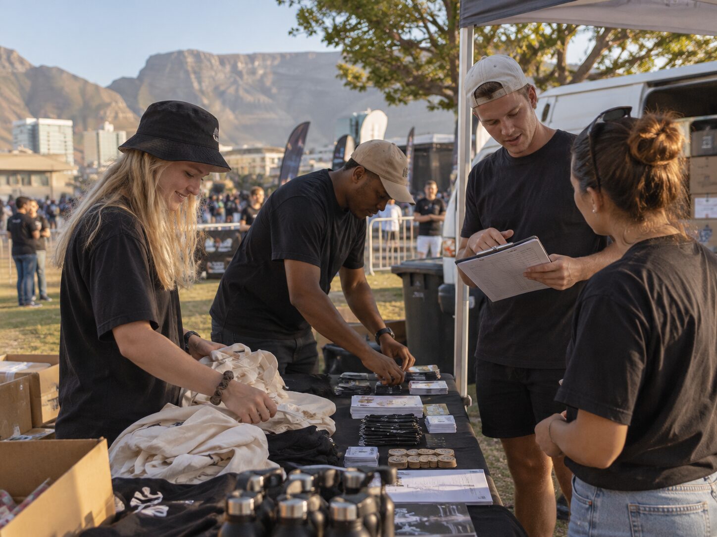 Event team preparing promotional materials and merchandise at an outdoor event in Cape Town.